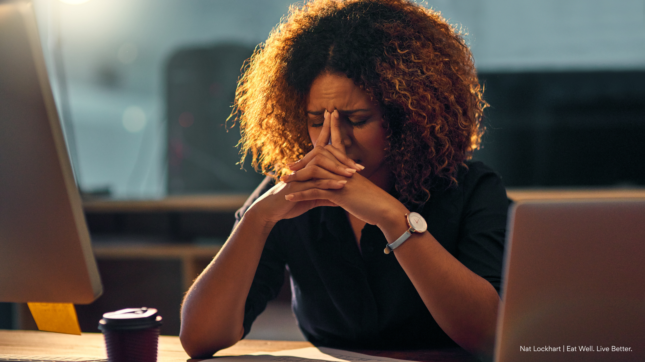 Woman sitting at a desk while overcoming a mid-afternoon energy crash with simple daily habits.